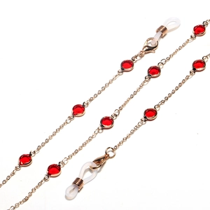 Detail of gold chain eyeglass strap with red faceted glass beads and silicone loops