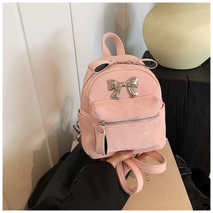 Détail du mini sac à dos rose avec noeud en métal argenté et texture en cuir mat de qualité