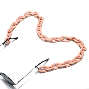 Vue détaillée d'une chaîne de lunettes en acrylique rose à gros maillons sur lunettes