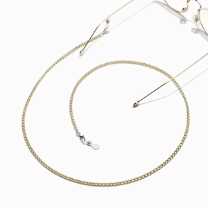 Detail of a gold metal glasses chain with non-slip silicone loops on a white surface