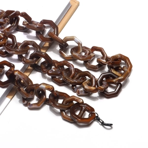 Detail of amber acrylic glasses chain with hexagonal links and marble texture