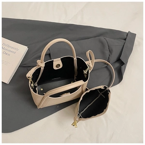 Detail of beige lychee leather bucket bag with inner pouch and magnetic closure