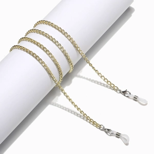 Detail of golden metal eyewear chain featuring silver lobster clasps and white silicone loops
