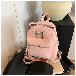 Détail du mini sac à dos en daim rose avec un nœud métallique argenté brillant