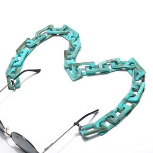 Dettaglio della catena per occhiali in acrilico marmorizzato a forma di cuore su bianco