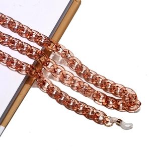 Details einer bernsteinfarbenen Brillenlkette aus Acryl mit goldenen Metallverschlüssen