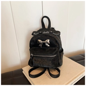 Détail d'un mini sac à dos noir avec texture craquelée vintage et nœud métallique argenté