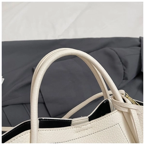 Detail of white lychee pattern leather handle with neat stitching and black interior lining