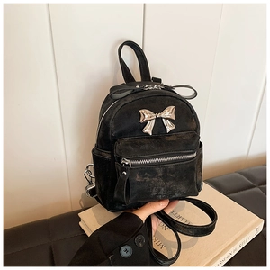 Gros plan du mini sac à dos rétro noir avec nœud métallique et texture en cuir grainé
