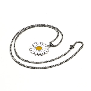 Macro view of daisy flower pendant with white enamel petals on a silver bead chain