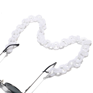 Macro view of translucent white hexagonal acrylic chain links on black sunglasses