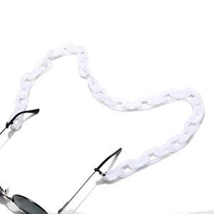 Détail de la grosse chaîne de lunettes en acrylique blanc avec attaches noires