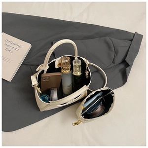 Detail of off-white lychee grain bucket bag with matching pouch and spacious interior