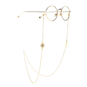Lunettes dorées à monture ronde avec chaîne en métal et pendentif marguerite