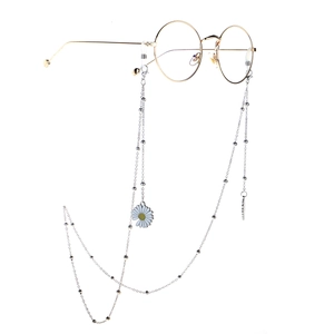 Chic silver eyewear chain with white daisy pendant on golden frame glasses