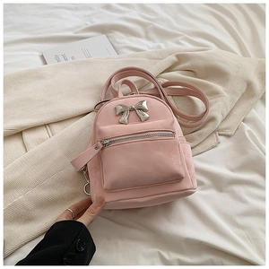 Détail du mini sac à dos rose avec nœud en métal argenté et finition veloutée