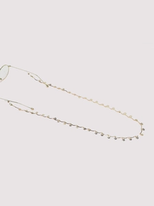 Detailed close-up of golden metal eyeglass chain with flower pendants and silicone loops