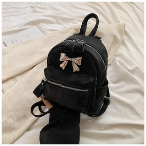 Détail du mini sac à dos en velours noir avec nœud métallique argenté élégant