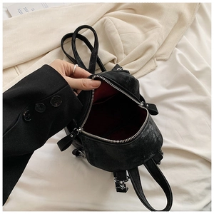 Vue intérieure du mini sac à dos noir avec doublure rouge et poche intérieure ouverte