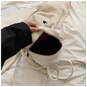 Détail intérieur d'un mini sac à dos en cuir PU blanc avec doublure rouge foncé