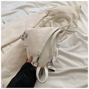 Détail du mini sac à dos crème avec crochets en métal argenté et bretelles