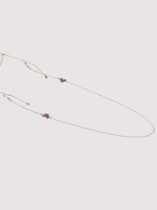 Detail of silver eyewear chain featuring decorative glittery purple butterfly charms