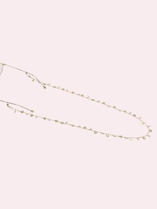 Detail of golden glasses chain with light green shells and white pearls decoration