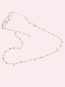 Detailed view of golden glasses chain with tiny pearls and delicate shell charms
