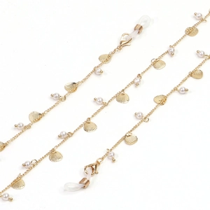 Detail of gold glasses chain with white pearls and golden shell charms on white background