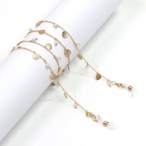 Golden eyewear chain featuring white faux pearls and round textured metal discs on a white stand