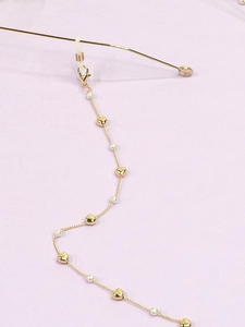 Detail der goldenen Brillenkette mit Herzanhängern und Perlen sowie Silikonschlaufen