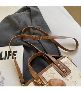Détail d'un sac seau beige et marron avec gaufrage en étoile et bandoulière