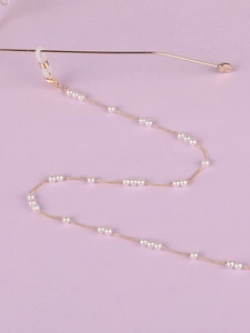 Détail de la chaîne de lunettes dorée avec perles blanches et boucles en silicone
