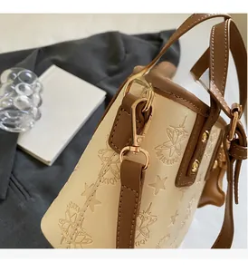 Détail du sac seau beige avec gaufrage étoiles et planètes et finitions dorées
