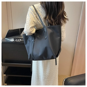 Détail du grand sac cabas en nylon noir présenté dans un bureau moderne