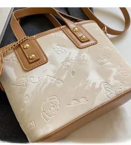 Gros plan du sac seau beige avec gaufrage de chien de dessin animé et bordure marron