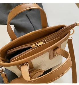 Détail de la fermeture éclair dorée et du gaufrage floral élégant sur le sac seau en cuir