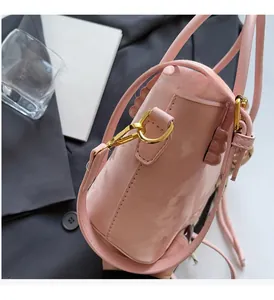 Detailaufnahme der rosa Lackleder-Beuteltasche mit goldenem D-Ring und Schultergurt