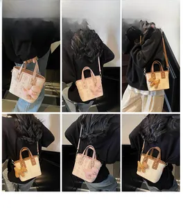 Détail du mini sac seau avec motif monogramme, breloque en peluche et bandoulière