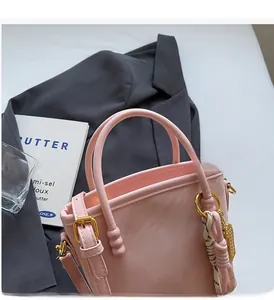 Detail der rosa Leder-Eimertasche mit Seidenschal-Anhänger und edlen Goldbeschlägen