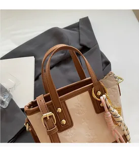 Dettaglio di una borsa a secchiello con stelle goffrate e tracolla su un blazer