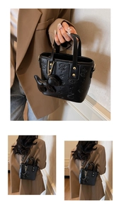 Détails du sac seau noir gaufré avec motifs d'étoiles et charmant pendentif chien