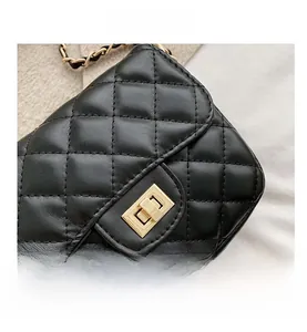 Detail shot of the black quilted pattern leather with gold metal twist-lock clasp