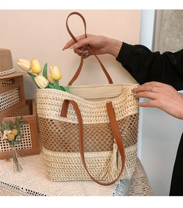 Detail of color-block woven tote featuring leather handles and tassel accents