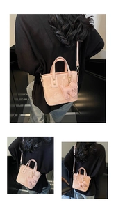 Détail du sac seau rose avec gaufrage de chien et fleurs et pendentif chiot mignon