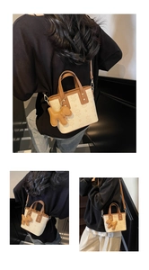 Détail du sac crème avec motif vintage, anses brunes et breloque en forme de chien