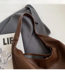 Gros plan sur un sac cabas en cuir marron vintage avec bandoulière large et doublure