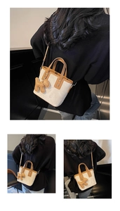 Mini sac seau crème avec breloque chiot et bordures en cuir marron sur le modèle