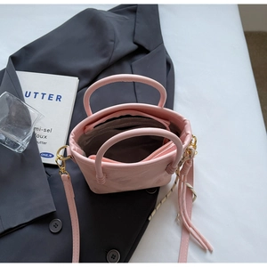 Detail der rosa PU-Leder-Beuteltasche mit geflochtener Quaste und verstellbarem Gurt