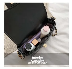 Interior capacity view of black quilted crossbody bag with cosmetics and gold chain